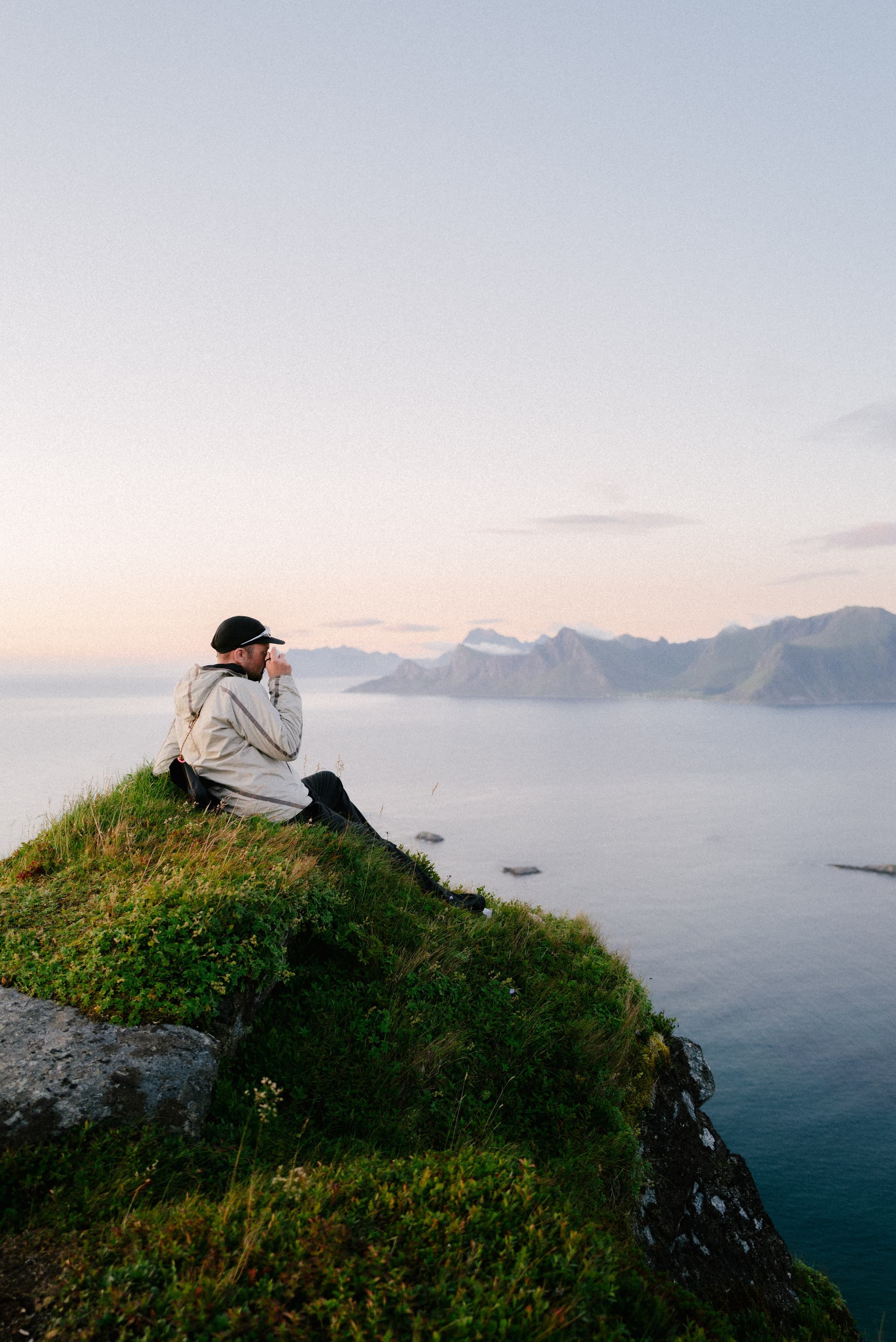 Christian sitting on a ridge in Lofoten at dusk